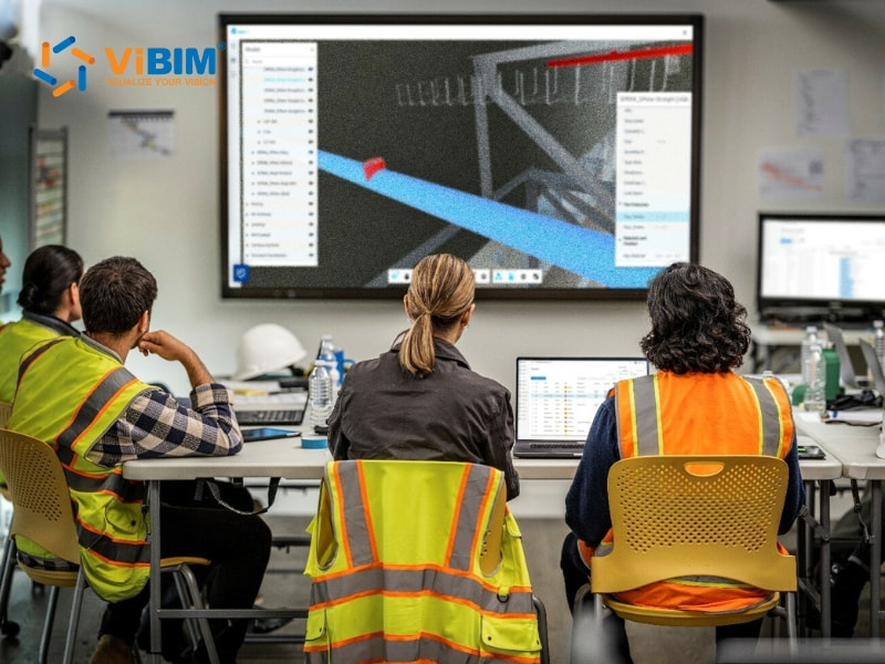Construction team reviewing clash detection results on large screen during BIM coordination meeting