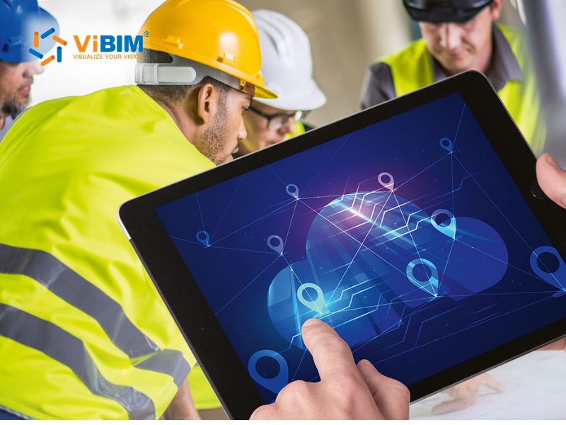 A construction field worker wearing a hardhat viewing a tablet on-site