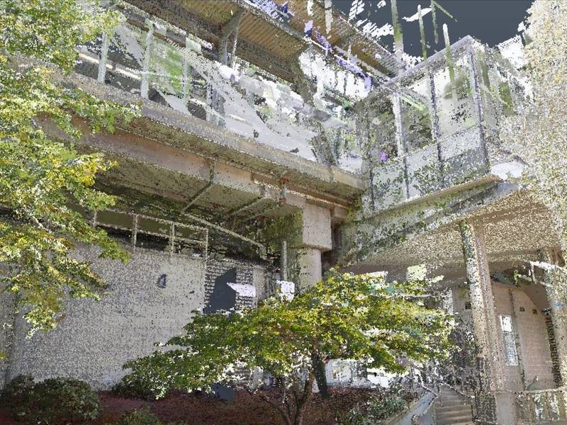 Point cloud scan of a multi-storey building facade with trees in front